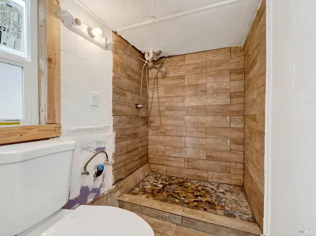 a bathroom with a toilet and a shower