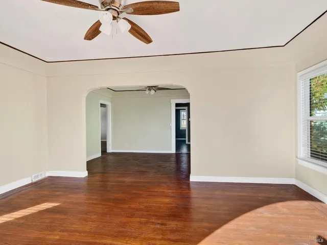 a view of a big room with wooden floor and windows