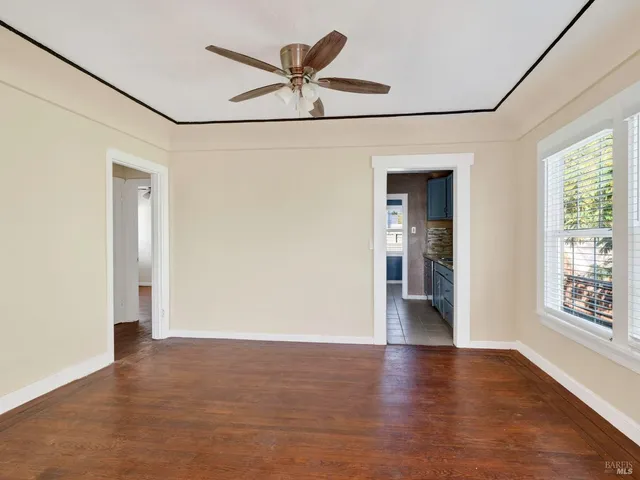 a view of a big room with wooden floor and windows