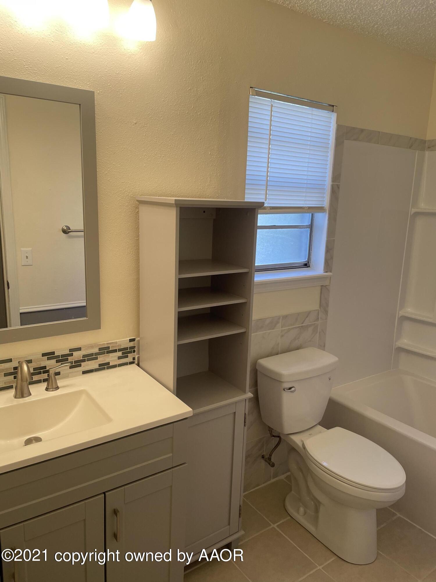 5309 Wheeler Lane Amarillo, TX 79110 - Photo 14 of 20 a bathroom with a toilet a sink and mirror
