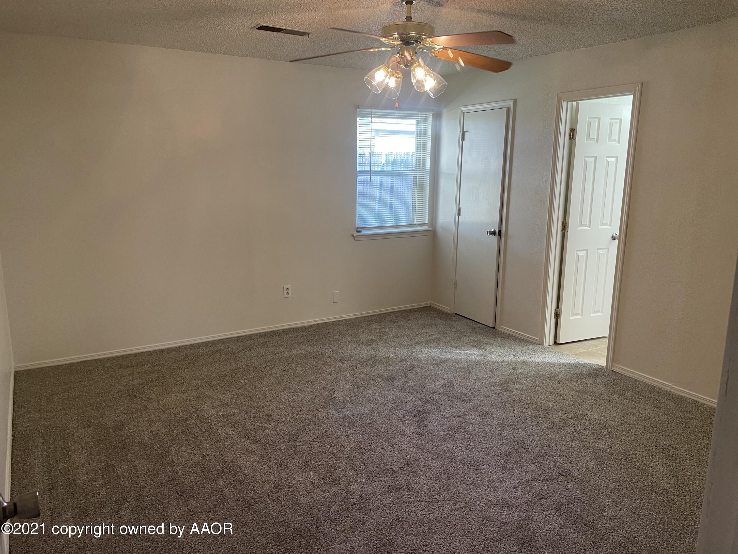 5309 Wheeler Lane Amarillo, TX 79110 - Photo 9 of 20 an empty room with a chandelier fan and windows