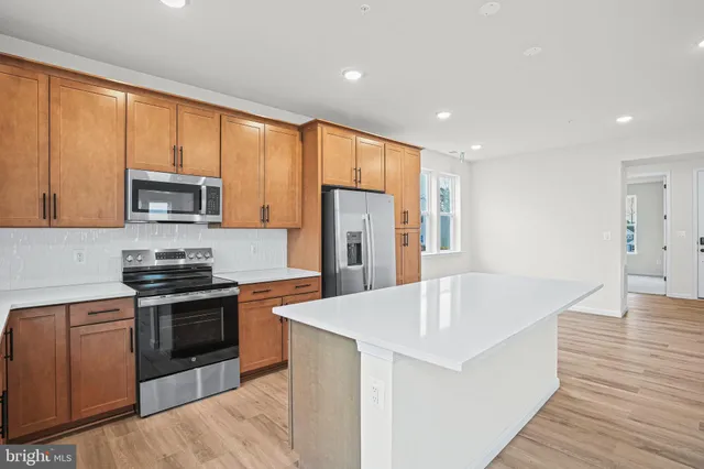 a kitchen with stainless steel appliances granite countertop a refrigerator stove top oven and sink