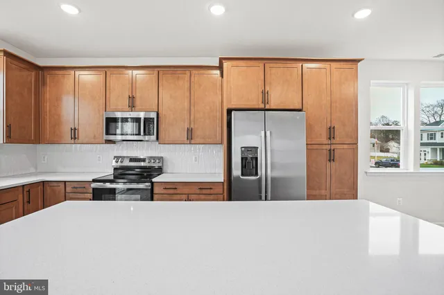 a kitchen with stainless steel appliances a refrigerator a stove a sink and a microwave