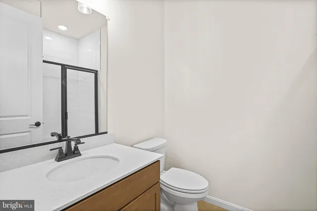 a bathroom with a sink vanity mirror and toilet