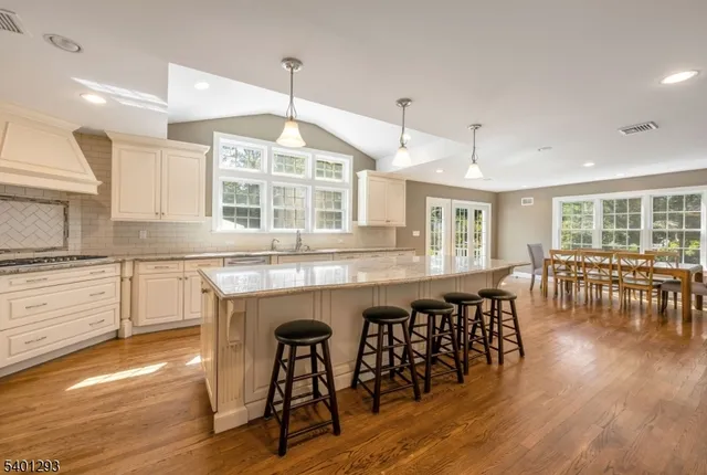a kitchen with granite countertop a dining table chairs and wooden floor