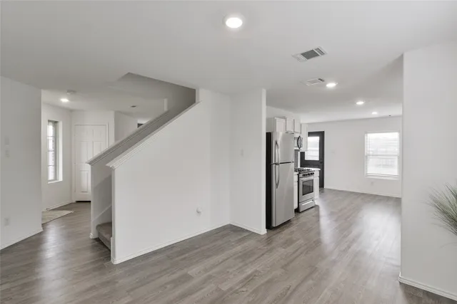 a view of empty room with wooden floor