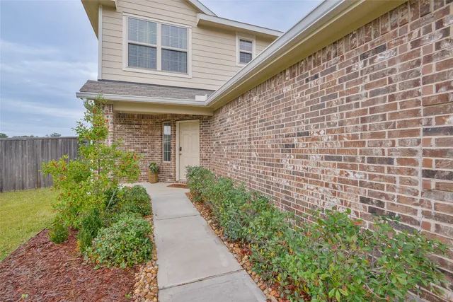 a pathway of a house with potted plants