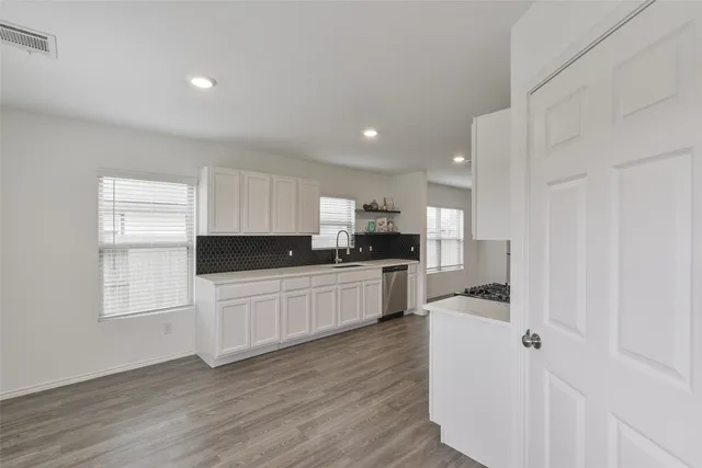 a kitchen with white cabinets and appliances