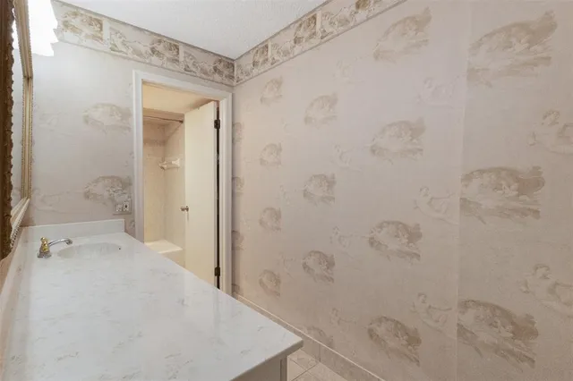 a bathroom with a granite countertop sink a mirror and a bathtub