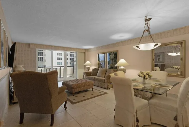 a living room with furniture a chandelier and a flat screen tv