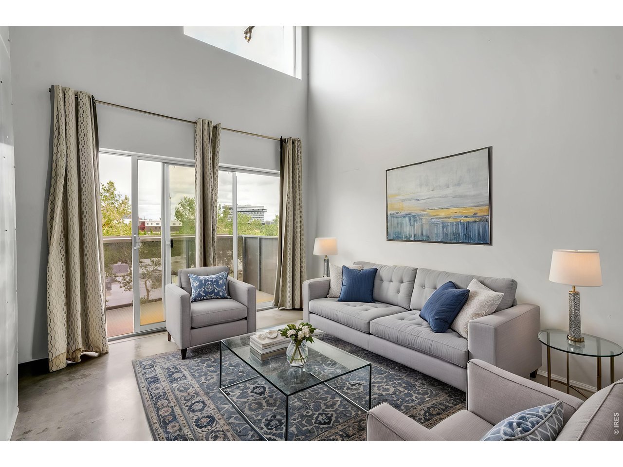 3457 Ringsby Court, Unit 327 Denver, CO 80216 - Photo 1 of 29 a living room with furniture and a large window