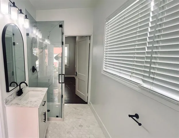 a bathroom with a sink a mirror and a shower