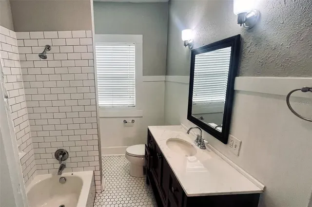 a bathroom with a sink a toilet a mirror and shower