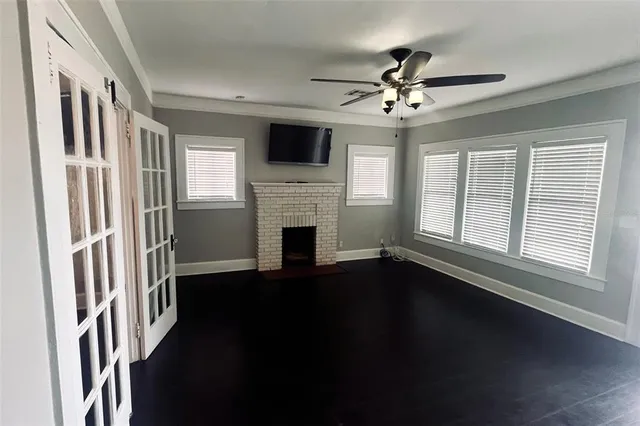 wooden floor in an empty room with a fireplace and a window
