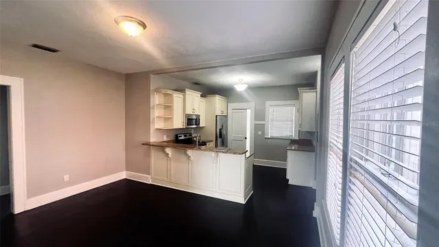 a view of a kitchen with a sink a refrigerator cabinets and a window