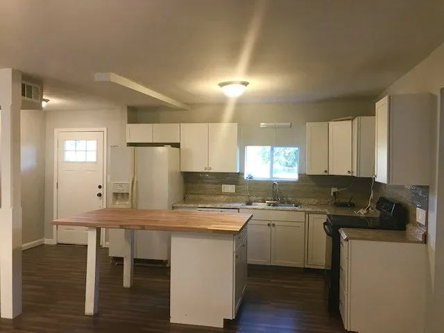 a kitchen with a sink cabinets and wooden floor