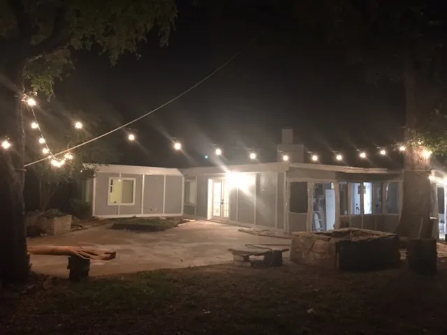 a view of an empty room with wooden floor and a fireplace