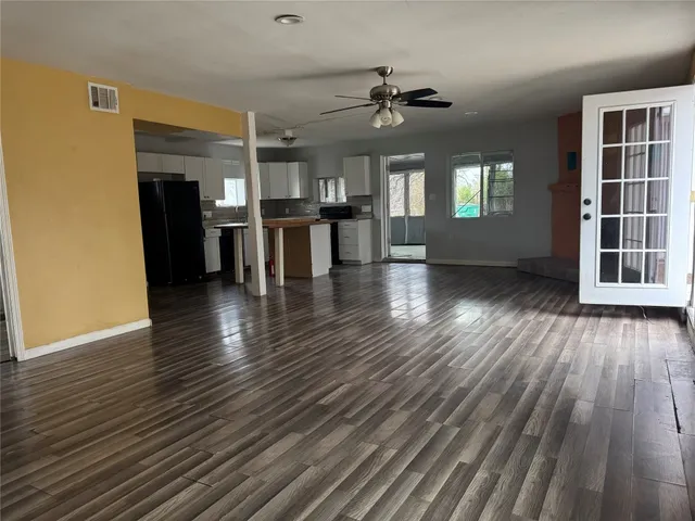 an empty room with a chandelier fan