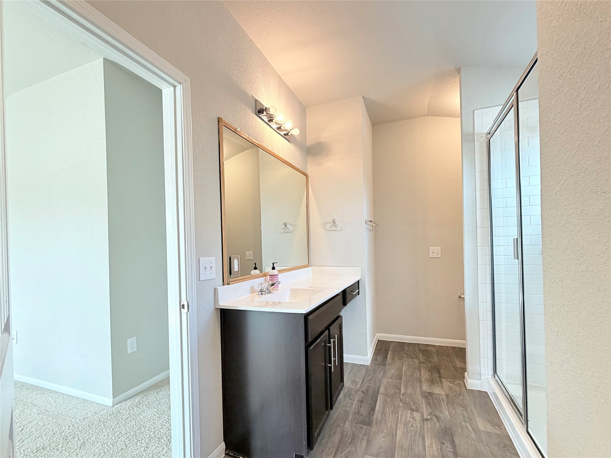 10502 Fulton Avenue Austin, TX 78754 - Photo 21 of 36 A well-lit bathroom features a single vanity with ample counter space and a modern glass-enclosed shower.