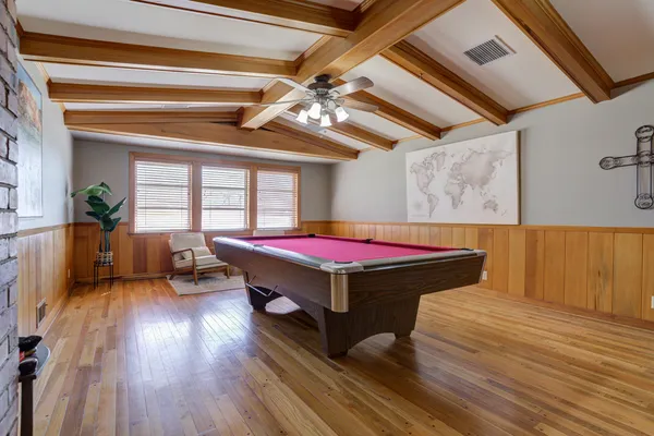 a room with pool table windows and wooden floor