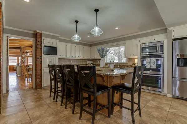a kitchen with a table chairs microwave and cabinets