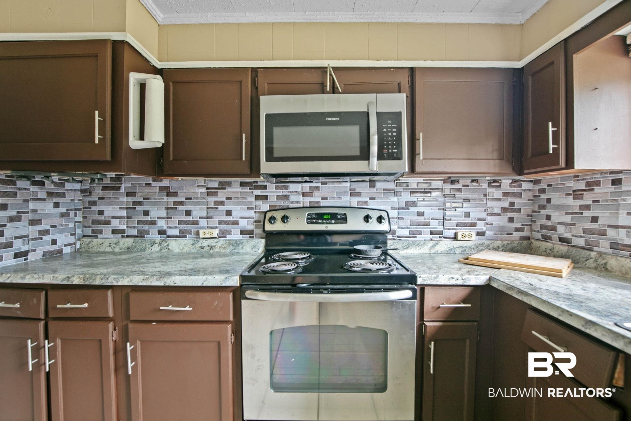 23240 County Road 47 Perdido, AL 36562 - Photo 17 of 29 Kitchen featuring stainless steel appliances, decorative backsplash, light countertops, ornamental molding, and dark brown cabinetry