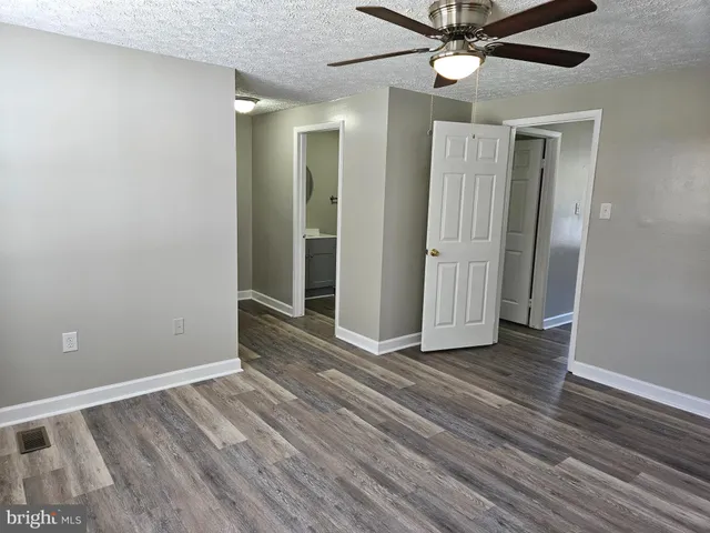 a view of an empty room with wooden floor