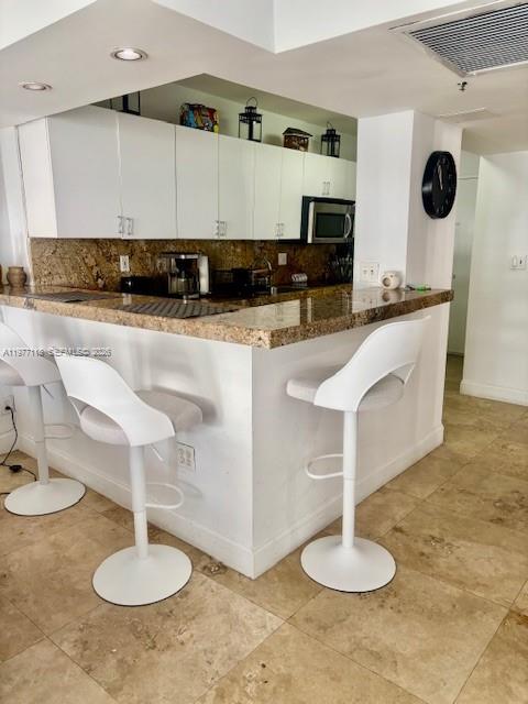 100 Lincoln Road, Unit 531 Miami Beach, FL 33139 - Photo 5 of 31 a kitchen with stainless steel appliances granite countertop a sink a stove a microwave a counter top space and cabinets