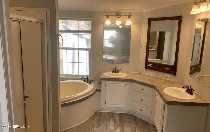 3980 Pinto Road Middleburg, FL 32068 - Photo 11 of 24 a bathroom with a sink double vanity granite tub and mirror