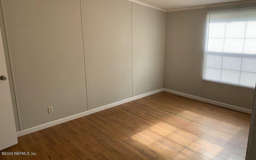 3980 Pinto Road Middleburg, FL 32068 - Photo 5 of 24 an empty room with wooden floor and windows