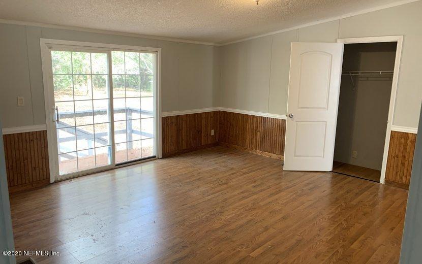 3980 Pinto Road Middleburg, FL 32068 - Photo 6 of 24 an empty room with wooden floor and windows