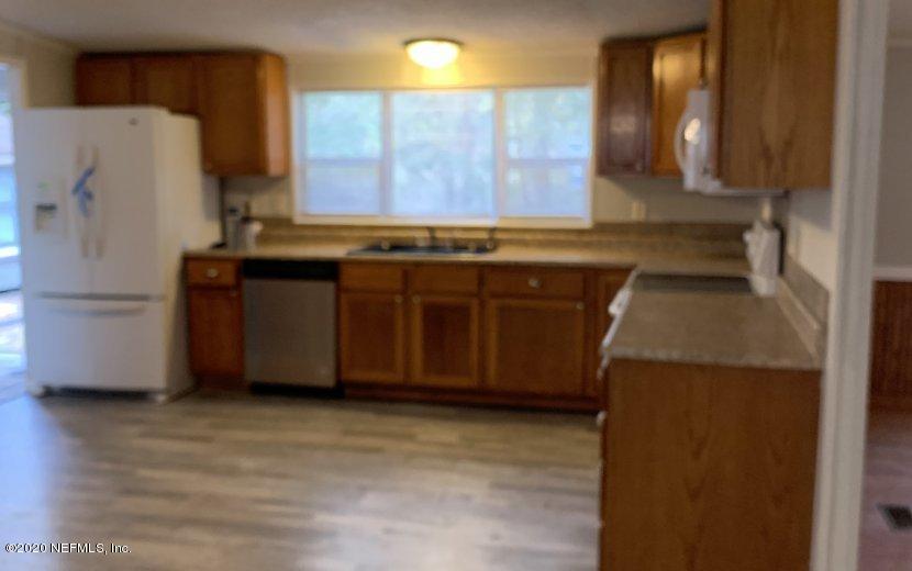 3980 Pinto Road Middleburg, FL 32068 - Photo 7 of 24 a kitchen with stainless steel appliances granite countertop a refrigerator a stove and a sink with wooden cabinets