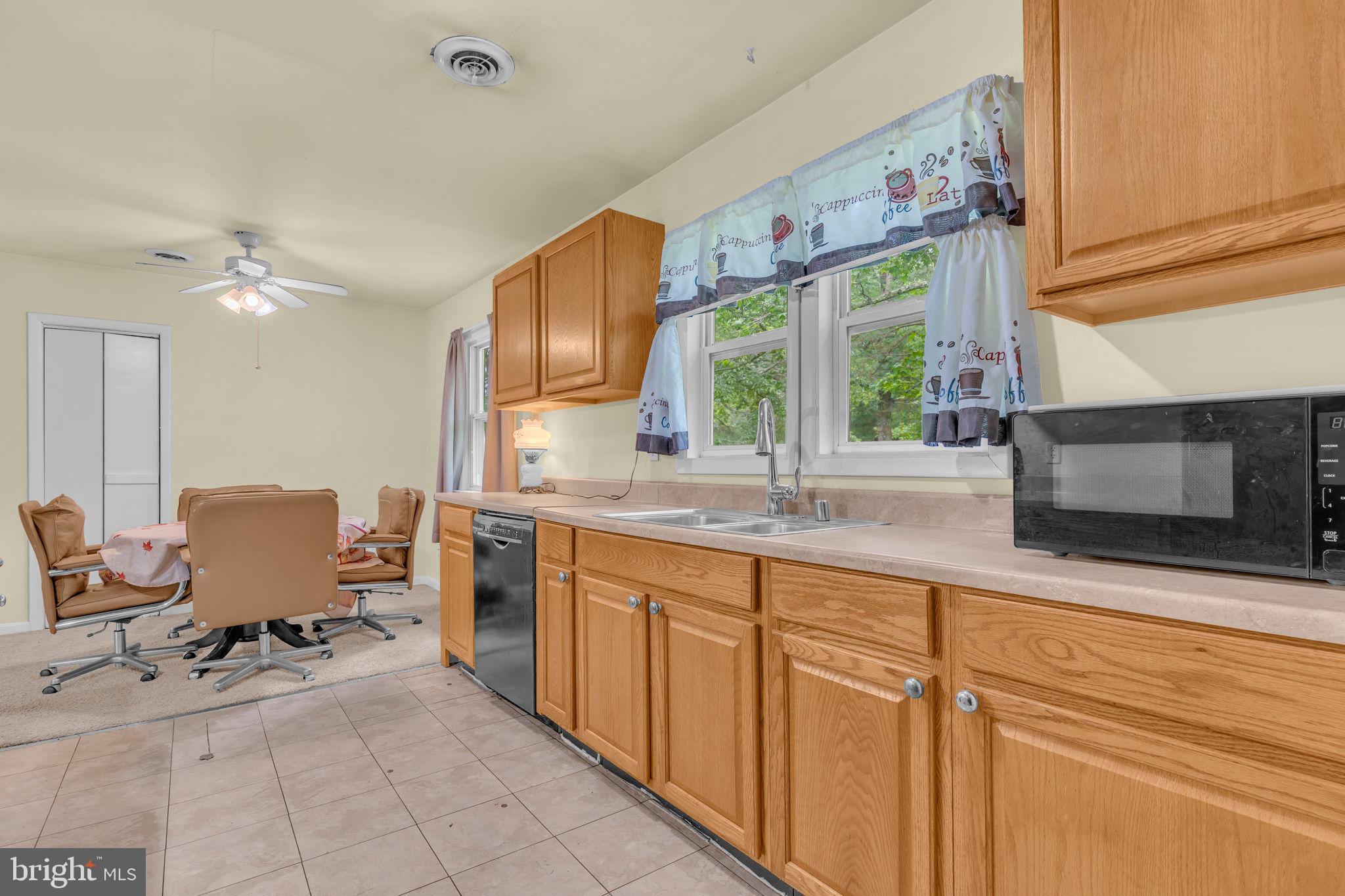 2159 Mathias Point Road King George, VA 22485 - Photo 8 of 22 a open kitchen with stainless steel appliances granite countertop a stove top oven a sink a dining table and chairs with the front door