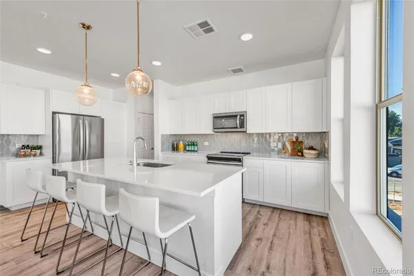 a kitchen with stainless steel appliances kitchen island a refrigerator and a stove top oven