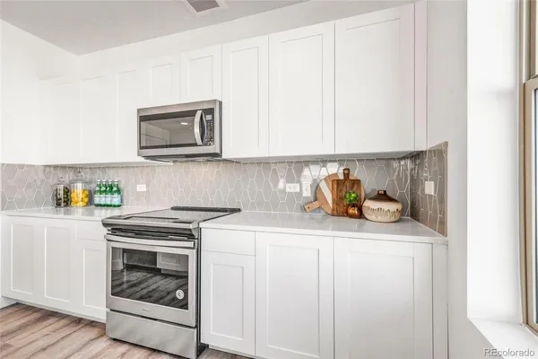 a kitchen with stainless steel appliances granite countertop a sink and a stove