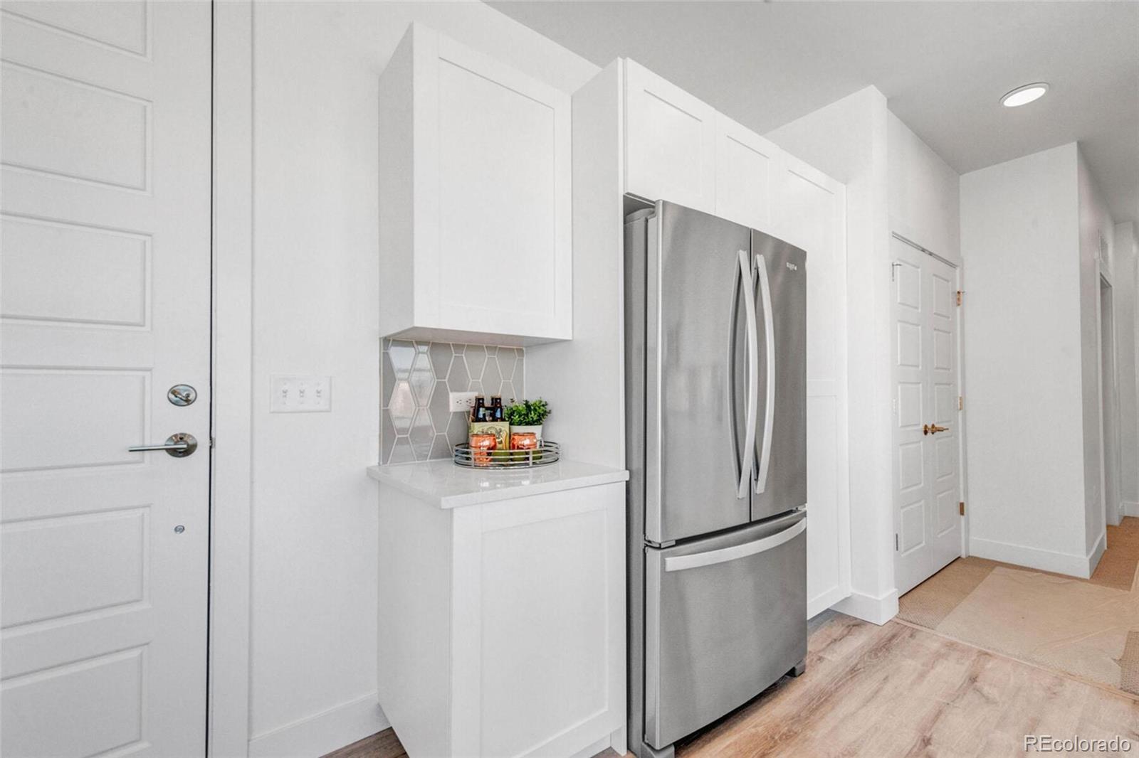 2899 West 52nd Avenue, Unit 301 Denver, CO 80221 - Photo 6 of 16 a white refrigerator freezer sitting in a kitchen