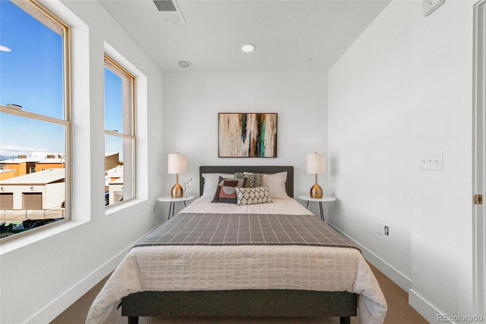 2899 West 52nd Avenue, Unit 301 Denver, CO 80221 - Photo 8 of 16 a bedroom with a bed and a large mirror