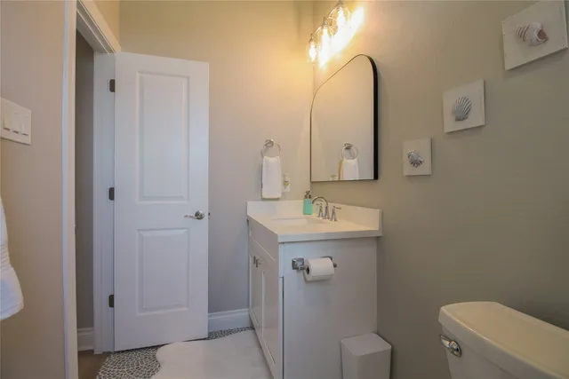a bathroom with a toilet a sink a vanity and mirror