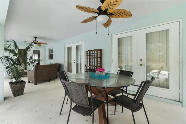 a dining room with furniture a chandelier and wooden floor