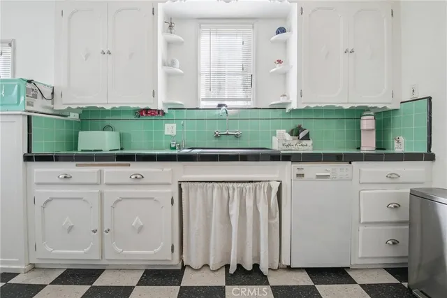 a kitchen with white cabinets and a stove