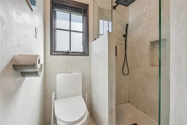 a bathroom with a toilet and a shower