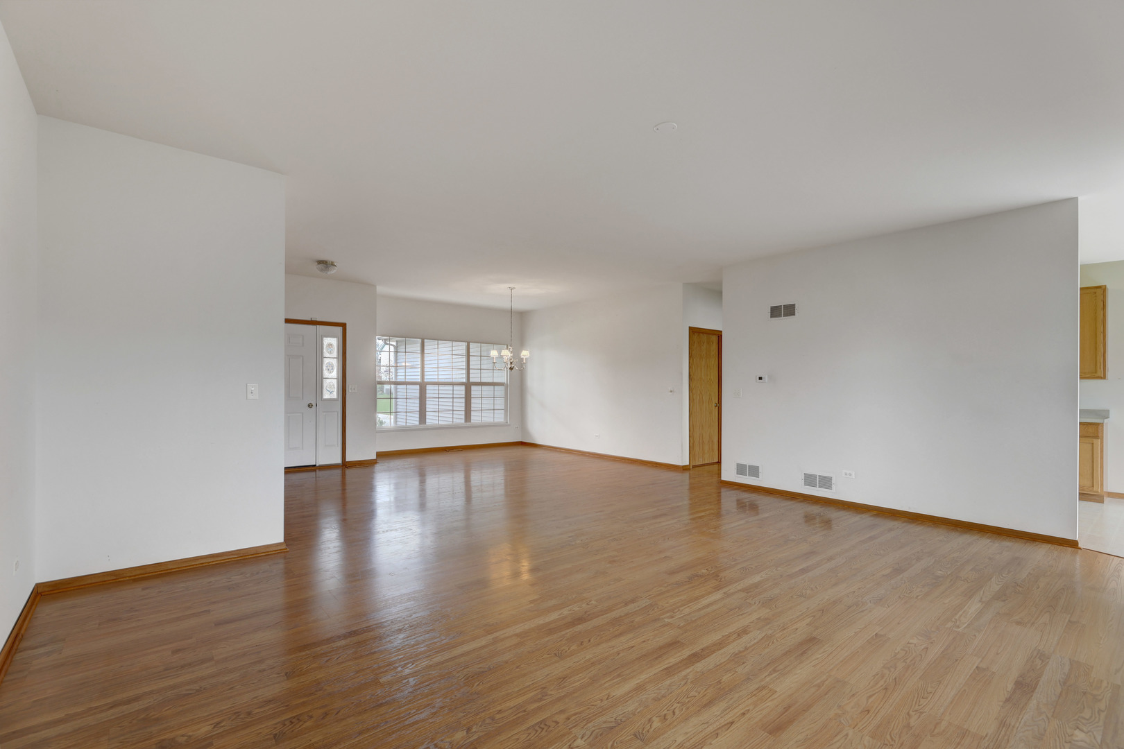 3206 Chestnut Drive McHenry, IL 60051 - Photo 6 of 30 a view of an empty room with window and wooden floor