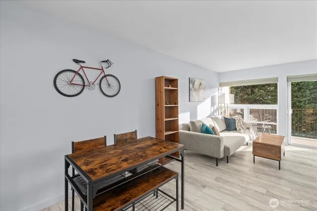 a kitchen with stainless steel appliances granite countertop a stove top oven a sink dishwasher a dining table and chairs with wooden floor