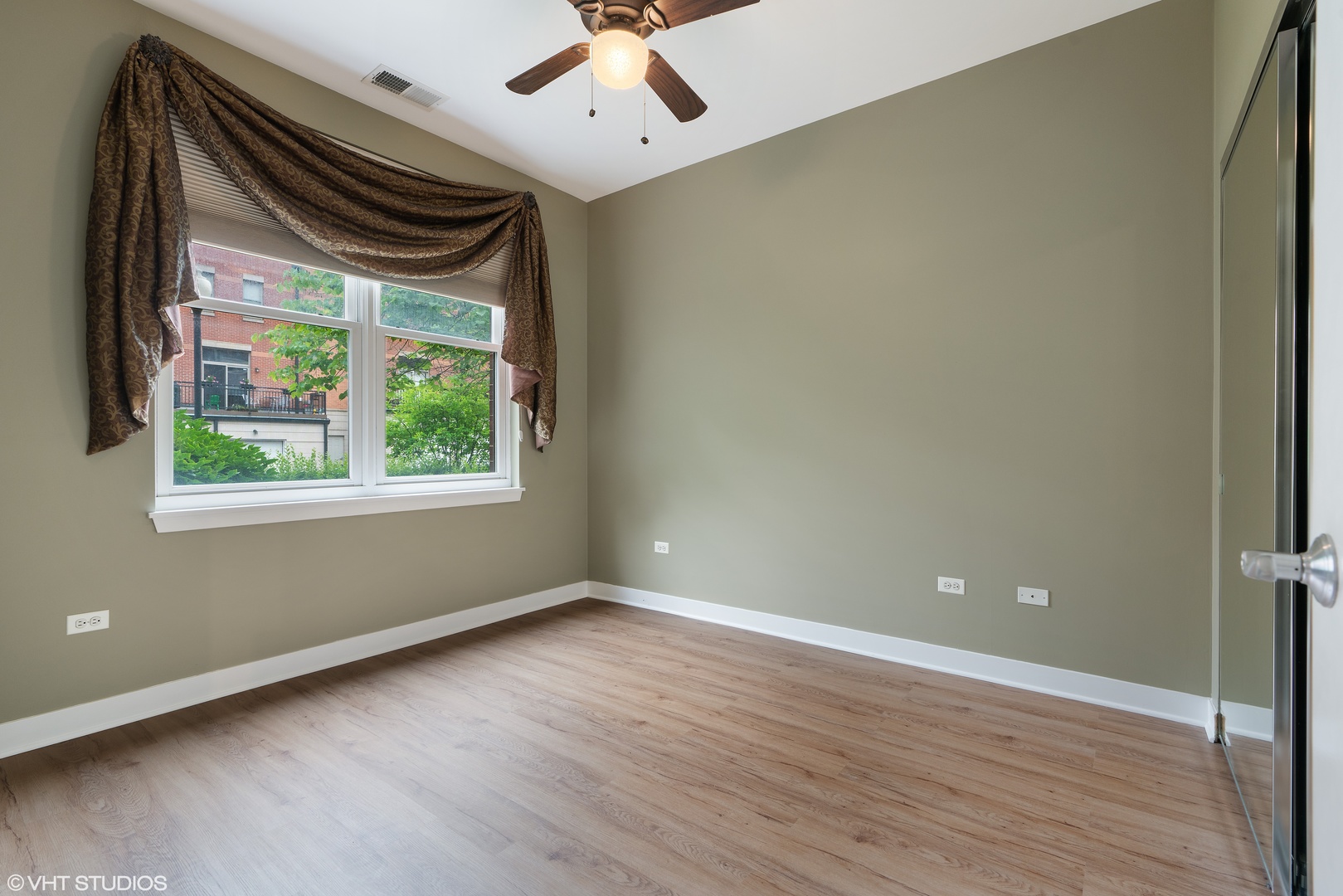 1509 South Halsted Street, Unit 211 Chicago, IL 60607 - Photo 10 of 13 a view of an empty room with wooden floor and a window