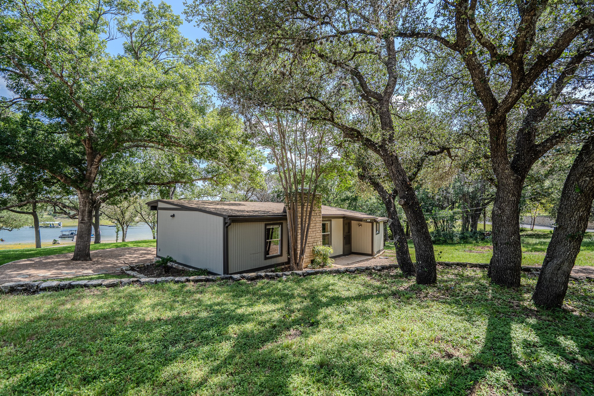 16013 Edwards Drive Austin, TX 78734 - Photo 1 of 18 A charming single-story home nestled among mature trees with distant water views.