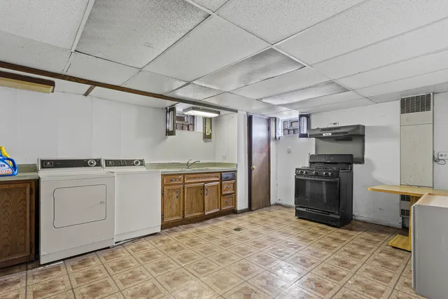 a kitchen with granite countertop a refrigerator and a stove top oven