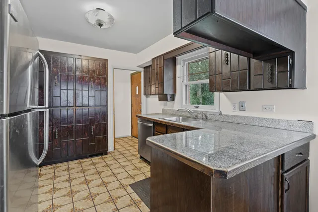 a kitchen with a sink a counter top space and stainless steel appliances