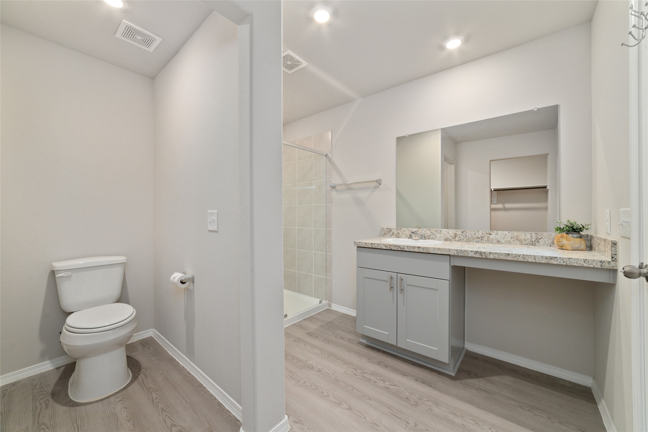 14232 Shasta Ridge Drive Conroe, TX 77303 - Photo 14 of 26 Primary bathroom with bright lighting and a clean layout, featuring a large mirror and an open feel that connects to the closet.