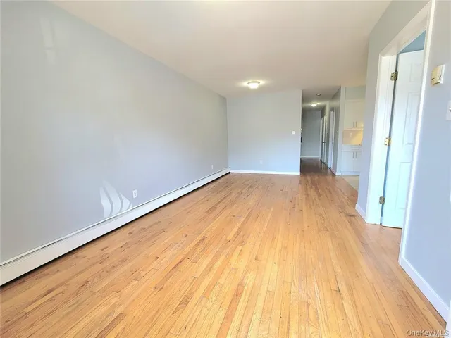 a view of a big room with wooden floor and brick walls