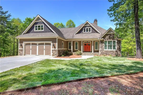 a front view of a house with yard and green space